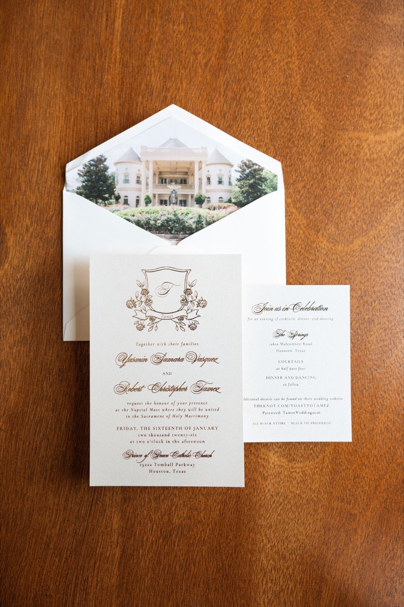 Ivory wedding invitation suite with a gold crest and building-view envelope liner