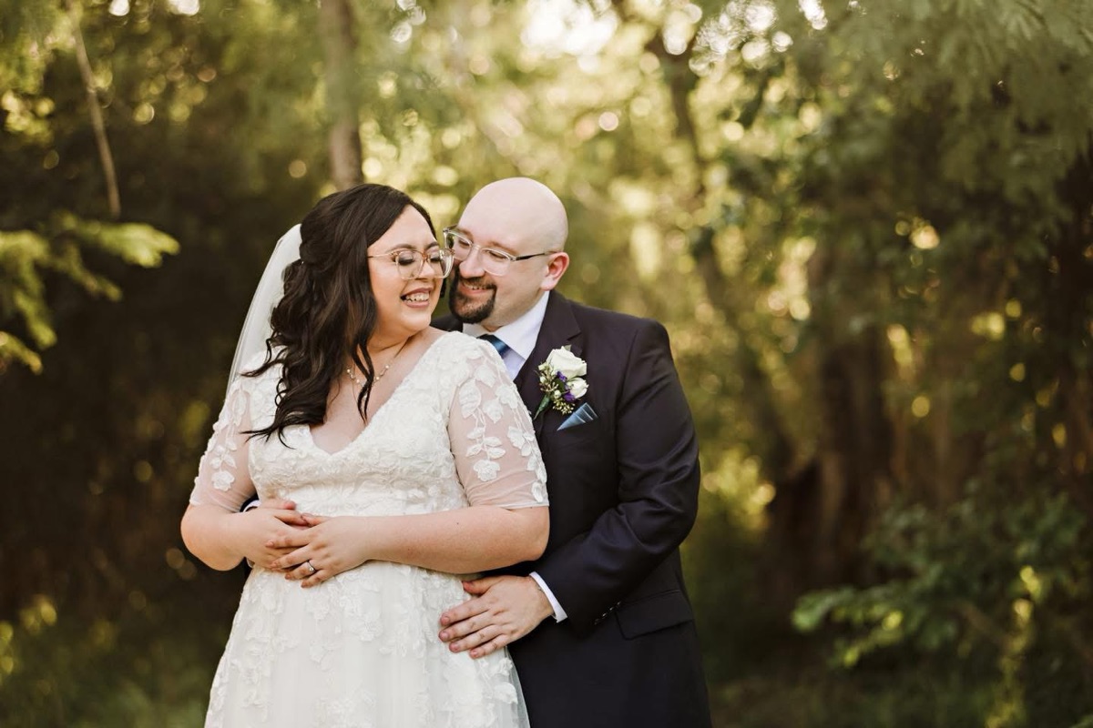 Couple embracing outdoors among green trees