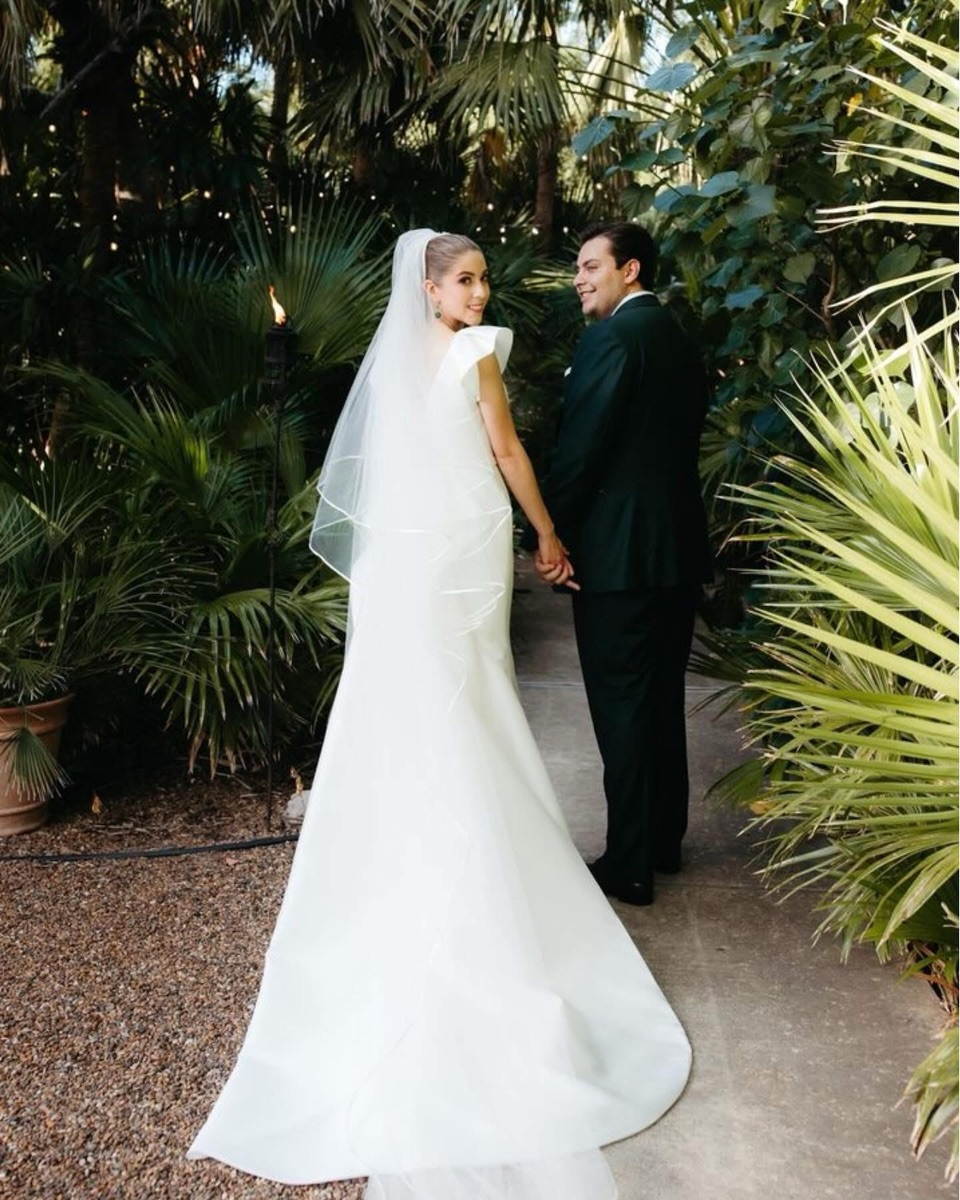 Bride and groom walking through a garden path