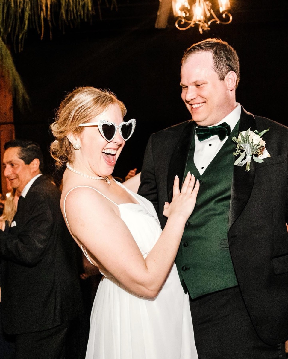 Bride and groom laughing with guests at the celebration